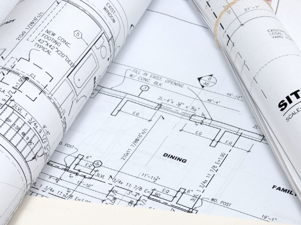 rolled up plans with drawings and measurements written on them