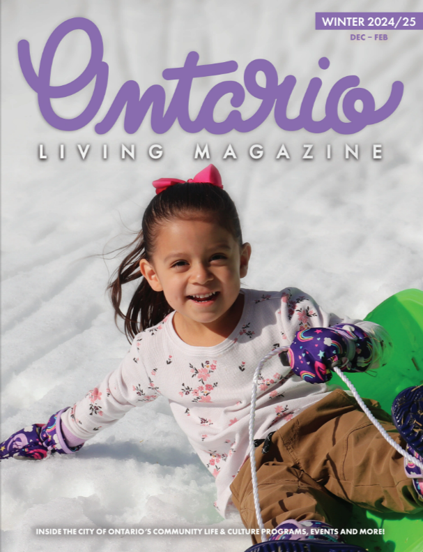 Small girl sledding down a snowy hill on a bright green sled. 